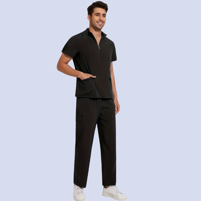Man wearing black medical scrub top and pants smiling and standing